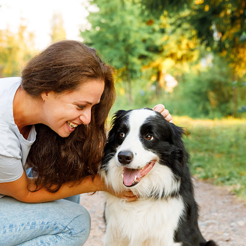 happy female owner with border collie outside